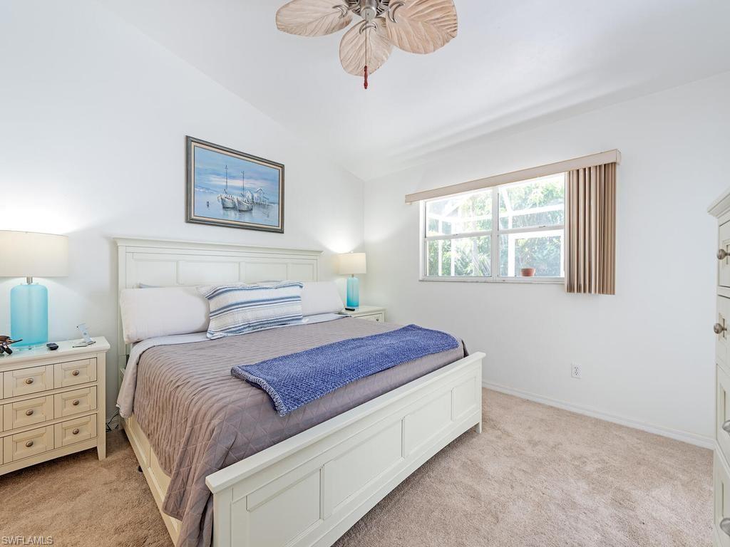 472 St Andrews Boulevard Naples, FL 34113 - Photo 13 of 18 a bedroom with a bed and a chandelier