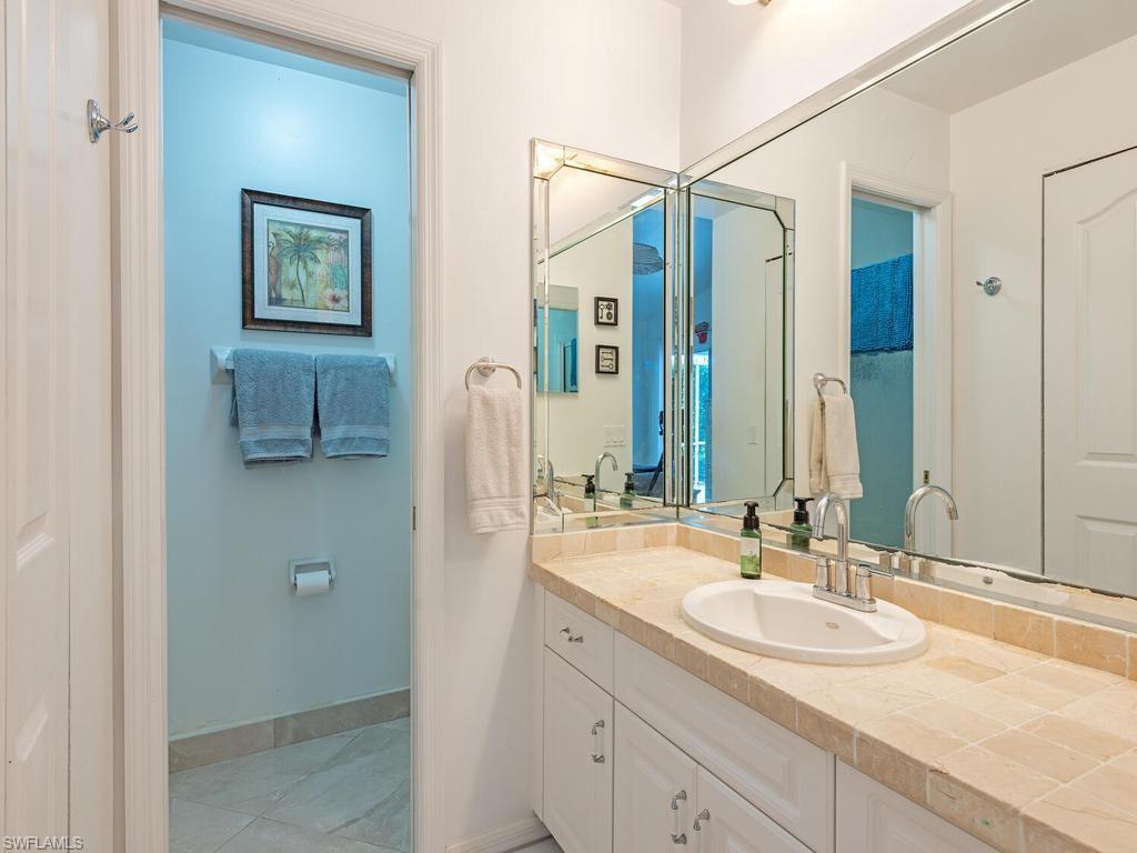 472 St Andrews Boulevard Naples, FL 34113 - Photo 14 of 18 a bathroom with a sink and a mirror