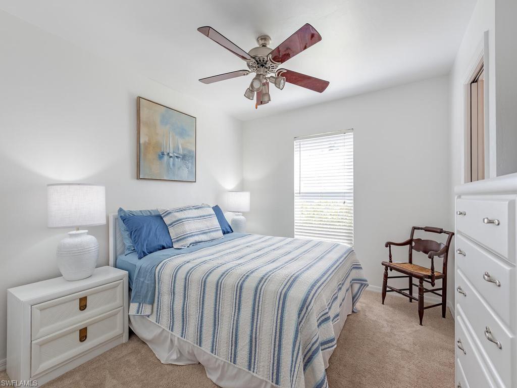 472 St Andrews Boulevard Naples, FL 34113 - Photo 15 of 18 a bedroom with a bed and a chandelier
