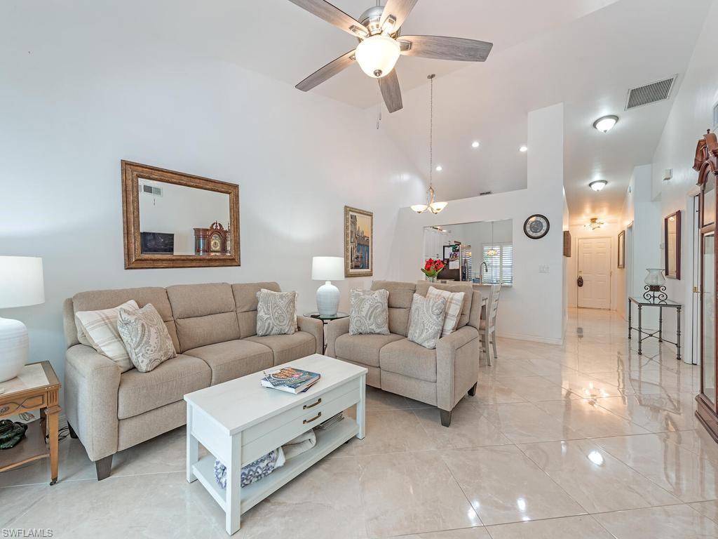 472 St Andrews Boulevard Naples, FL 34113 - Photo 8 of 18 a living room with furniture and a chandelier