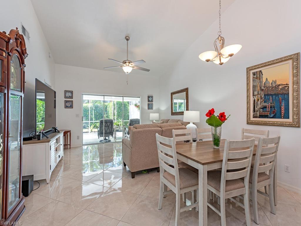 472 St Andrews Boulevard Naples, FL 34113 - Photo 10 of 18 a dining room with furniture a livingroom with furniture wooden floor and a chandelier