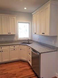 43 Harvard Street, Unit 1 Winchester, MA 01890 - Photo 5 of 13 a kitchen with granite countertop stainless steel appliances white cabinets granite counter tops and a hard wood floors