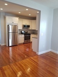 43 Harvard Street, Unit 1 Winchester, MA 01890 - Photo 6 of 13 a kitchen with granite countertop a refrigerator and a stove top oven
