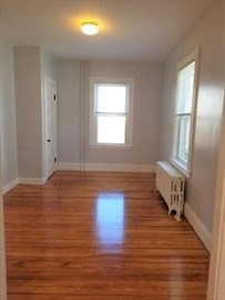 43 Harvard Street, Unit 1 Winchester, MA 01890 - Photo 7 of 13 an empty room with wooden floor and windows