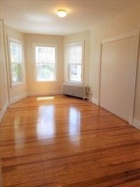 43 Harvard Street, Unit 1 Winchester, MA 01890 - Photo 8 of 13 an empty room with wooden floor and windows