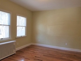 43 Harvard Street, Unit 1 Winchester, MA 01890 - Photo 9 of 13 an empty room with wooden floor and windows