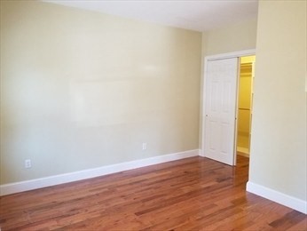 43 Harvard Street, Unit 1 Winchester, MA 01890 - Photo 10 of 13 a view of an empty room with wooden floor and a window