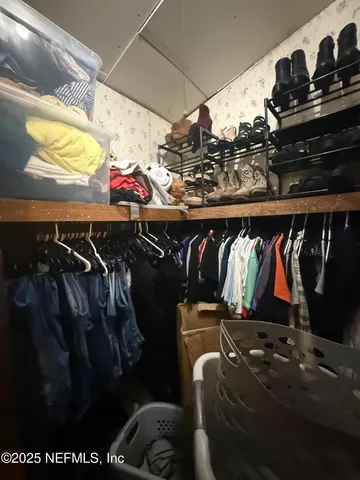 a view of walk in closet with clothes and shoes