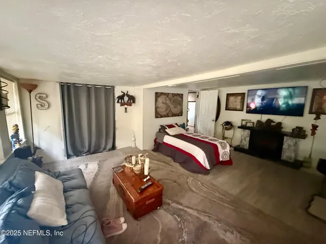 a spacious bedroom with a bed window and couch