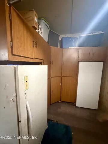 a utility room with wooden floor and cabinets