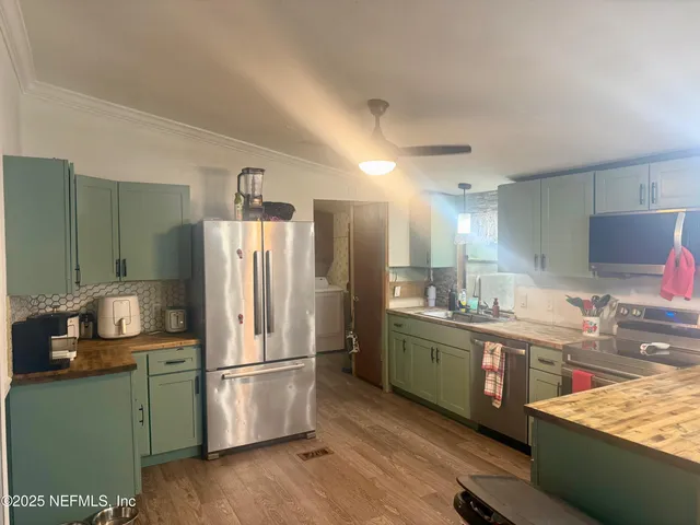 a kitchen with stainless steel appliances granite countertop a refrigerator and a sink
