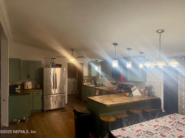 a kitchen with stainless steel appliances kitchen island granite countertop a sink refrigerator and cabinets