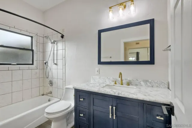 a bathroom with a tub a toilet a sink and mirror