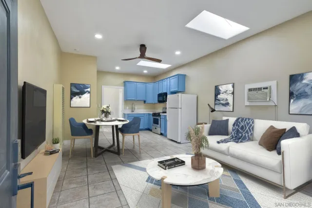 a living room with furniture kitchen view and a flat screen tv