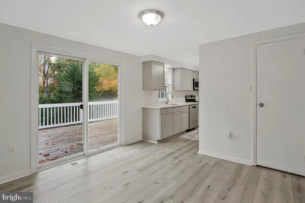 a kitchen with stainless steel appliances a sink and wooden floor