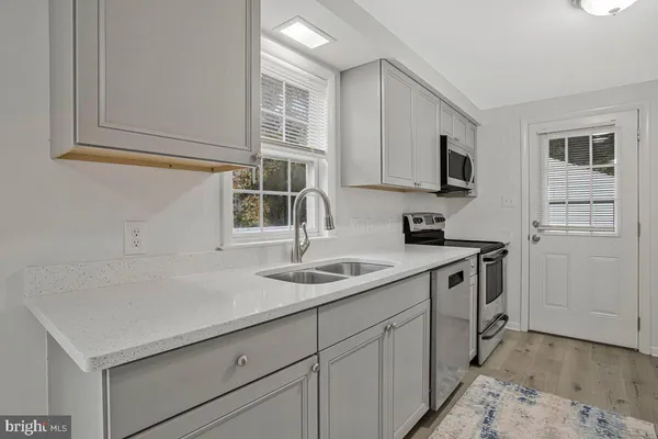 a kitchen with stainless steel appliances granite countertop a sink stove and microwave