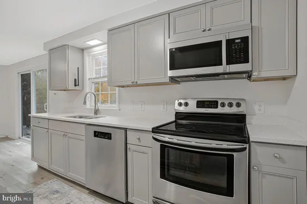 a kitchen with cabinets stainless steel appliances and a sink