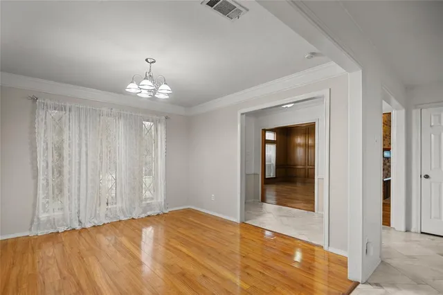 a view of a hallway with wooden floor and chandelier