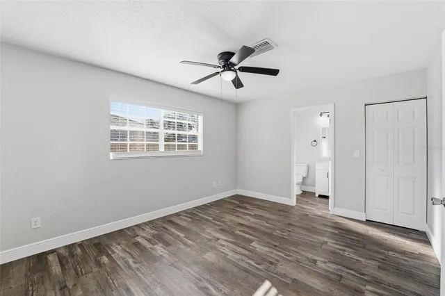 a view of empty room with wooden floor and ceiling fan