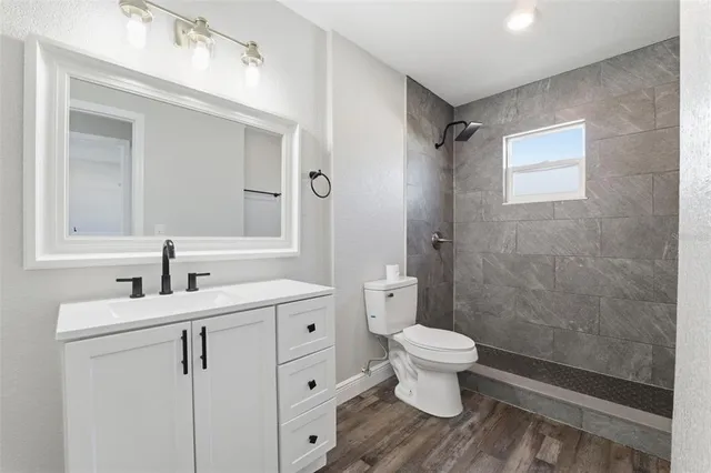 a bathroom with a sink a toilet and shower