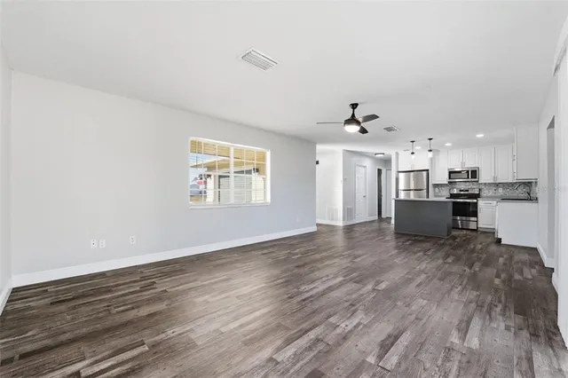 a view of a kitchen with a sink a refrigerator and window