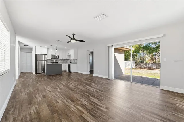 a view of a kitchen with wooden floor and a window