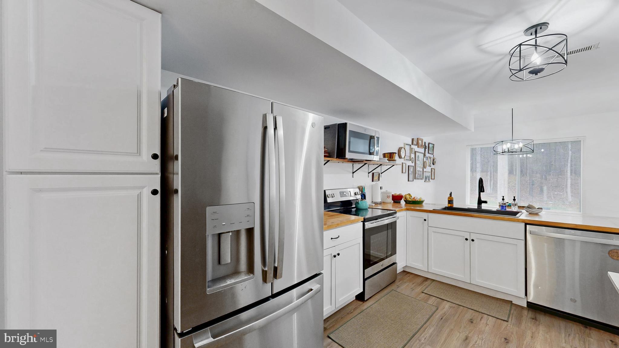 433 East Wind Drive Dover, DE 19901 - Photo 22 of 61 a kitchen with white cabinets and stainless steel appliances