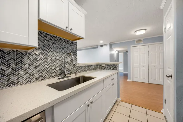 a kitchen with white cabinets and white appliances