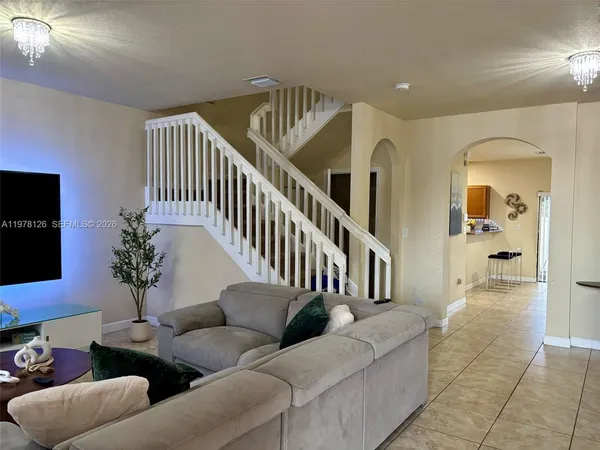 a living room with furniture and a potted plant