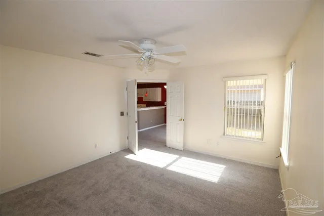 a view of a big room with windows and chandelier fan