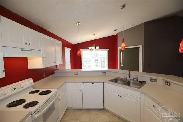 a kitchen with a sink stove and white cabinets
