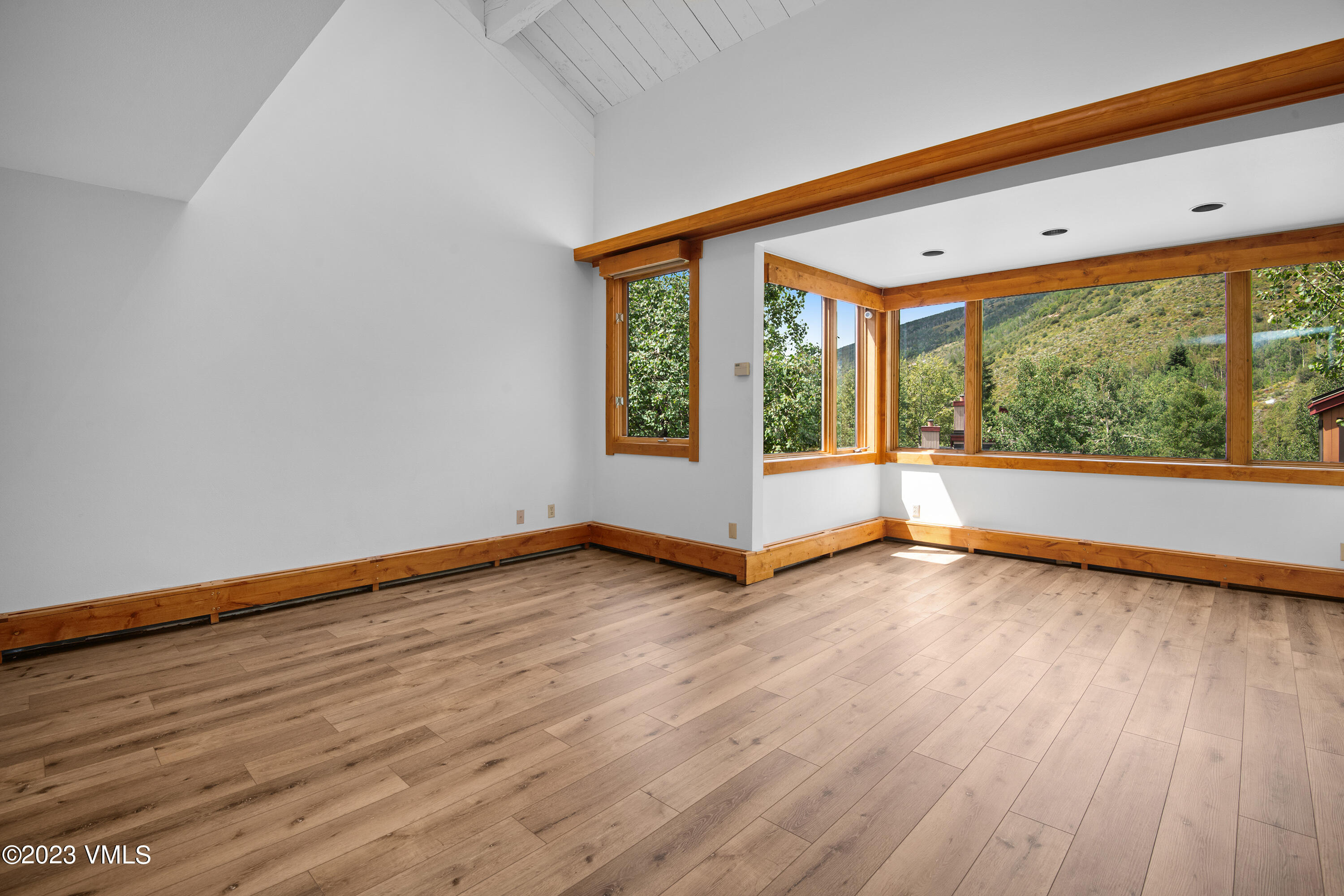 3094 Booth Falls Road, Unit 17 Vail, CO 81657 - Photo 4 of 27 a view of an empty room with wooden floor and a window