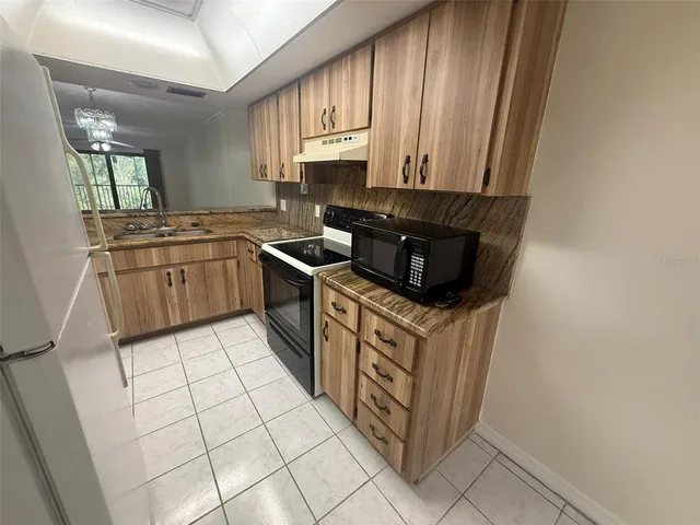 a kitchen with stainless steel appliances granite countertop a stove a sink and a microwave