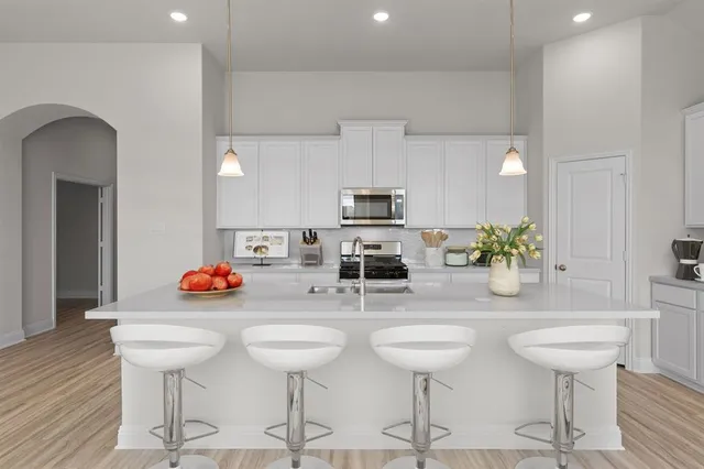 a kitchen with stainless steel appliances kitchen island granite countertop a dining table and chairs