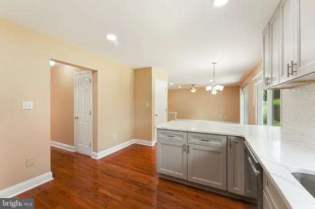 a view of a kitchen with a sink and dishwasher with wooden floor