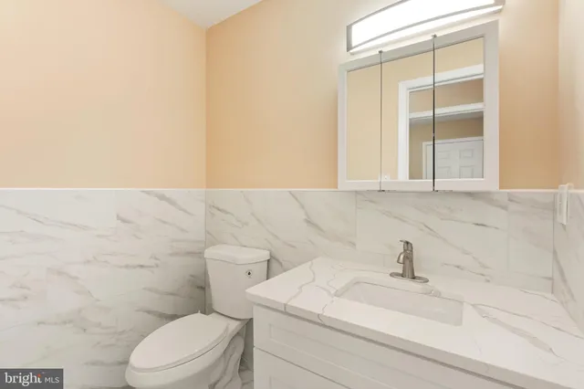 a bathroom with a sink a toilet and a mirror