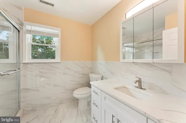 a bathroom with a sink a toilet and a window