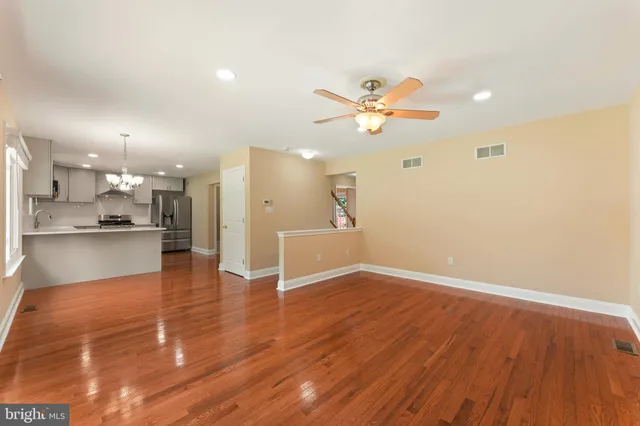 a view of a big room with wooden floor and a kitchen