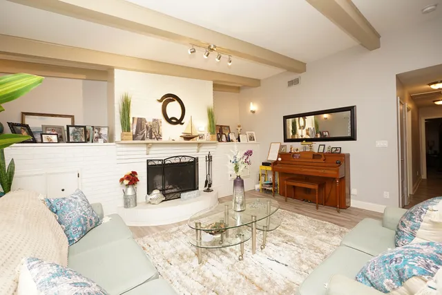 a living room with furniture a flat screen tv and kitchen view