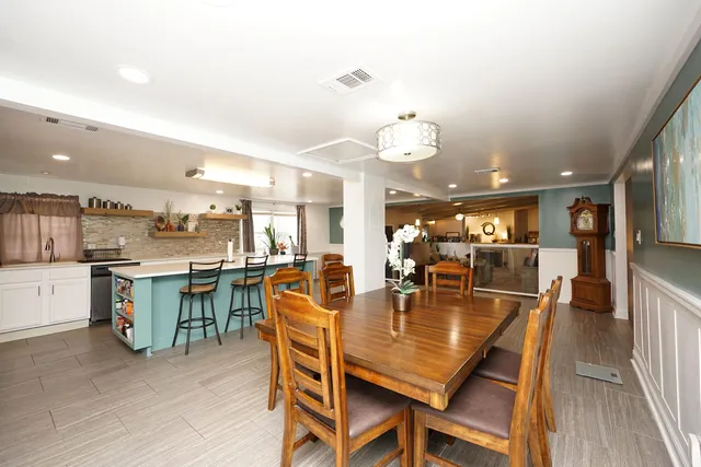 a dining room with kitchen island furniture a chandelier and kitchen view