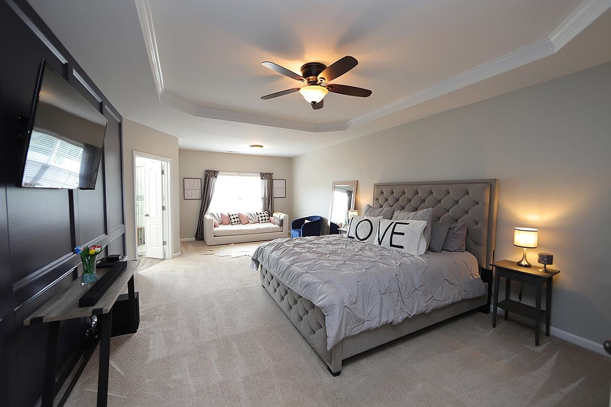 1105 Weston Green Loop Cary, NC 27513 - Photo 10 of 24 a bedroom with a bed and a chandelier