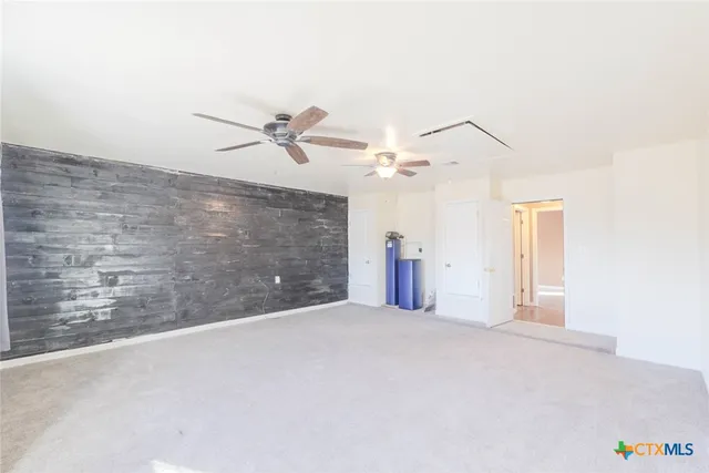 a view of an empty room with a ceiling fan