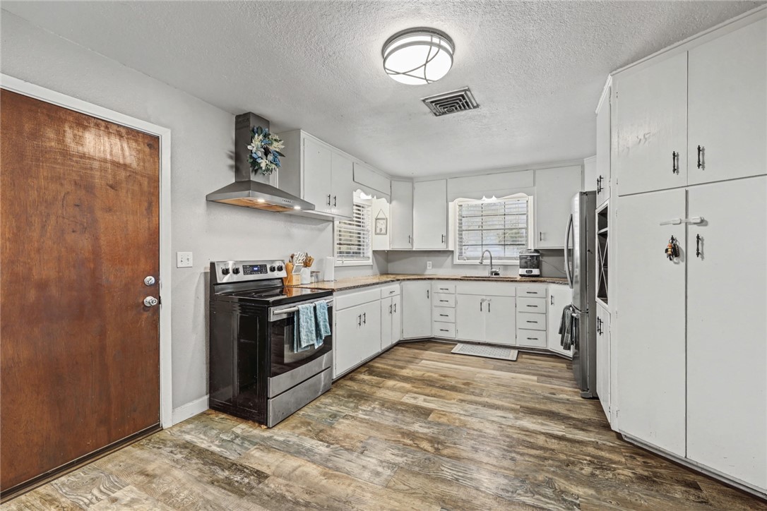 708 East Main Street Sinton, TX 78387 - Photo 7 of 28 a kitchen with stainless steel appliances granite countertop a sink a stove a refrigerator and cabinets