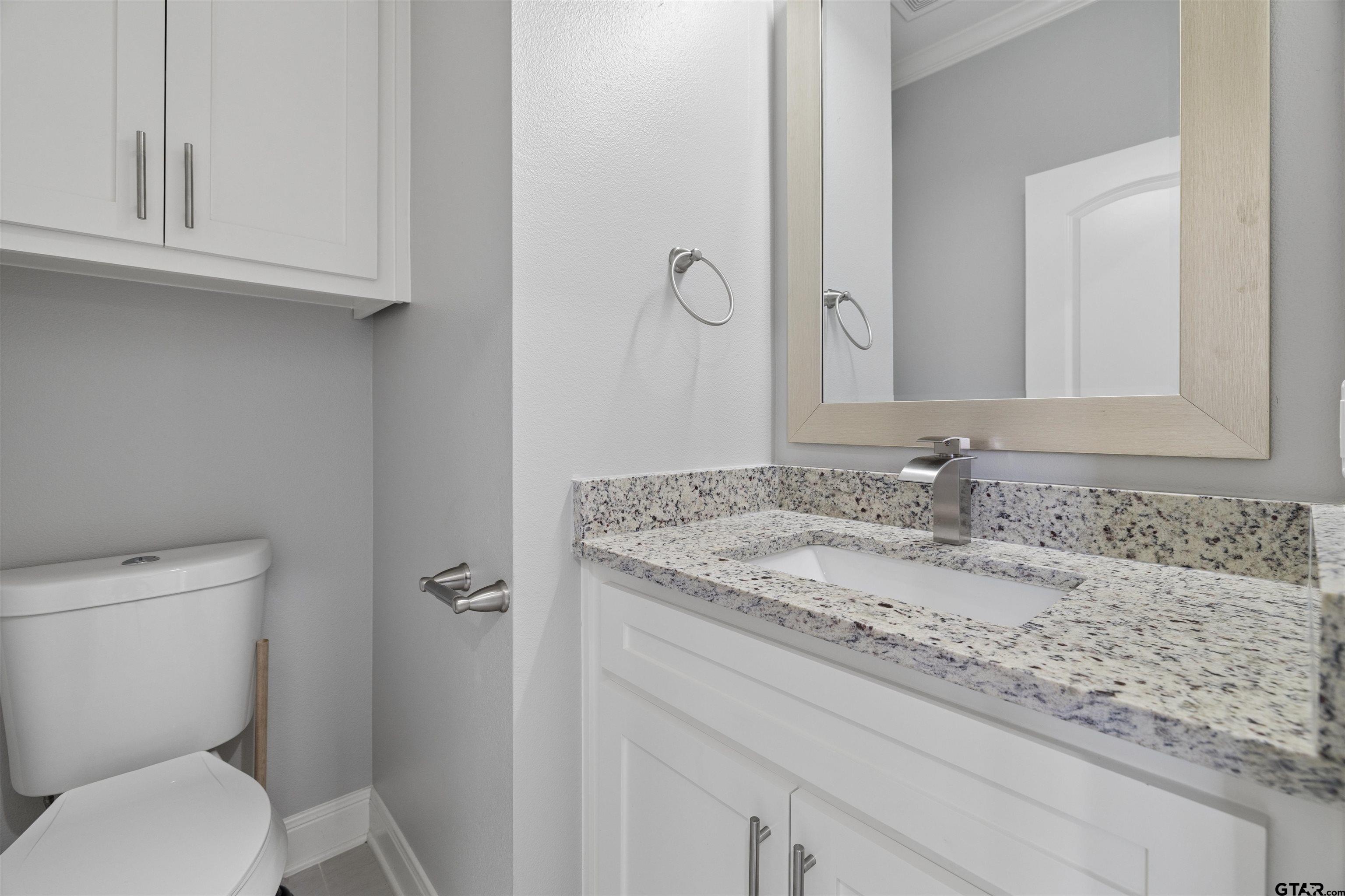 629 Third Street Bullard, TX 75757 - Photo 8 of 18 a bathroom with a granite countertop toilet sink and mirror