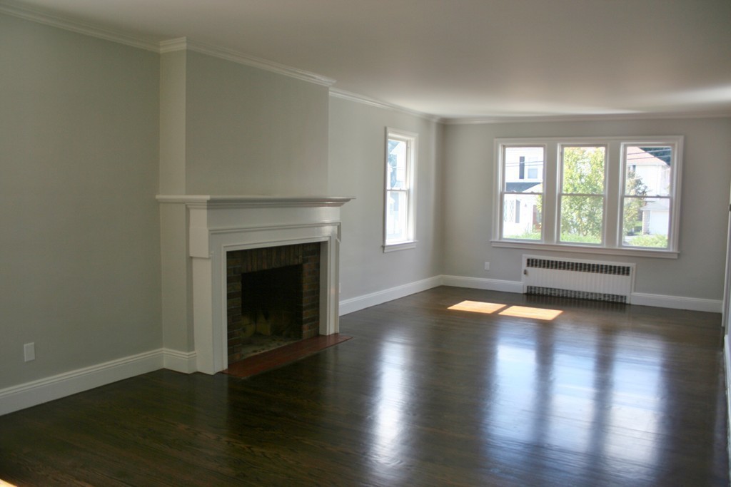 19 Dellwood Road Worcester, MA 01602 - Photo 5 of 26 an empty room with wooden floor and a fireplace