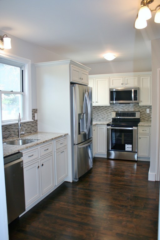 19 Dellwood Road Worcester, MA 01602 - Photo 9 of 26 a kitchen with granite countertop a refrigerator and a stove top oven