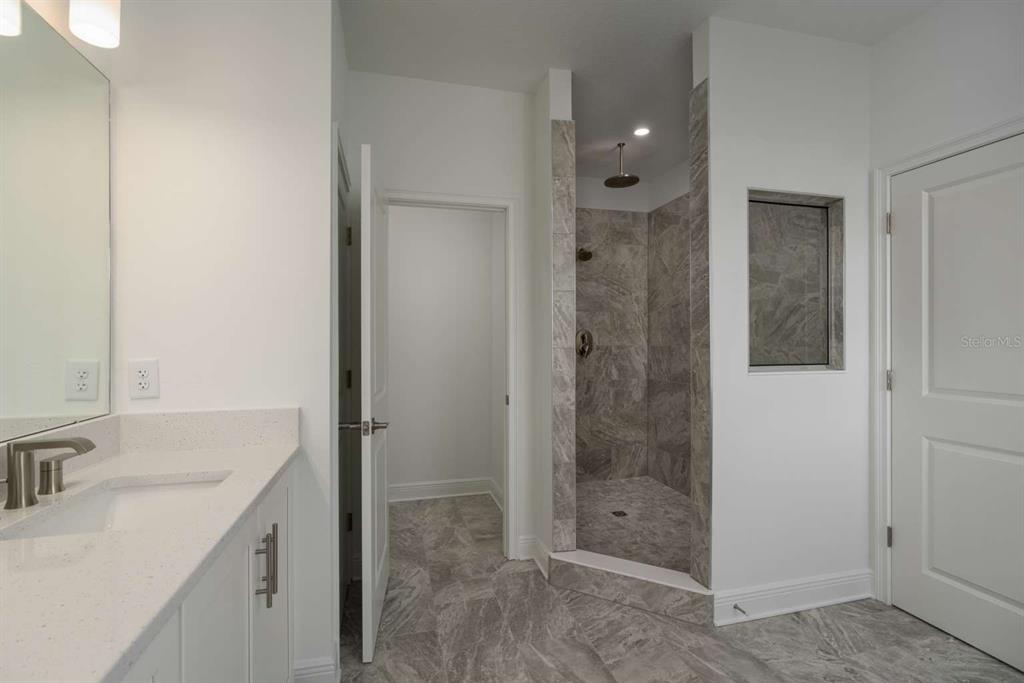 318 Rafael Boulevard Northeast St. Petersburg, FL 33704 - Photo 24 of 38 a bathroom with a shower sink and mirror