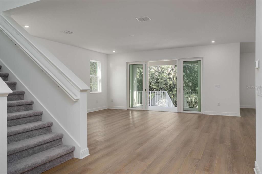318 Rafael Boulevard Northeast St. Petersburg, FL 33704 - Photo 5 of 38 a view of an empty room with wooden floor and a floor to ceiling window