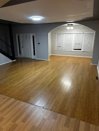 an empty room with wooden floor and door
