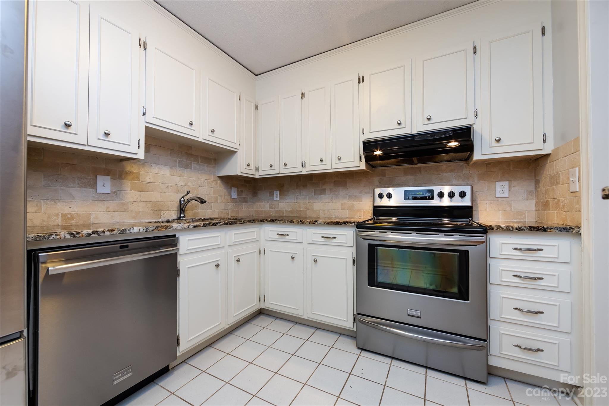 1336 Queens Road Charlotte, NC 28207 - Photo 21 of 36 a kitchen with granite countertop white cabinets and stainless steel appliances